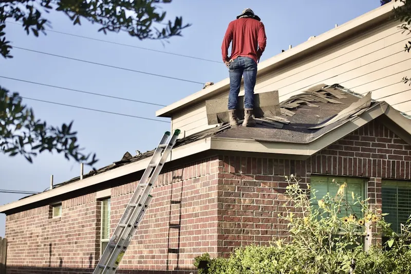 Professional roofer working on a residential roof in Olney Town